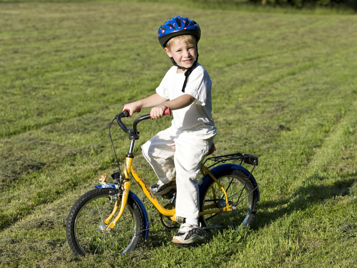 Cậu bé tự tin đạp xe trẻ em dưới nắng vàng buổi sáng