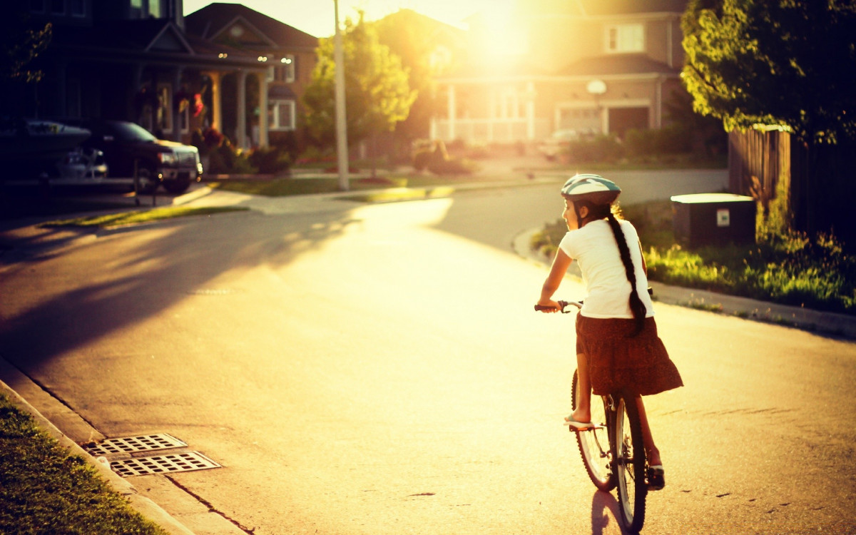 Em bé chạy xe đạp đi học dưới nắng hồi