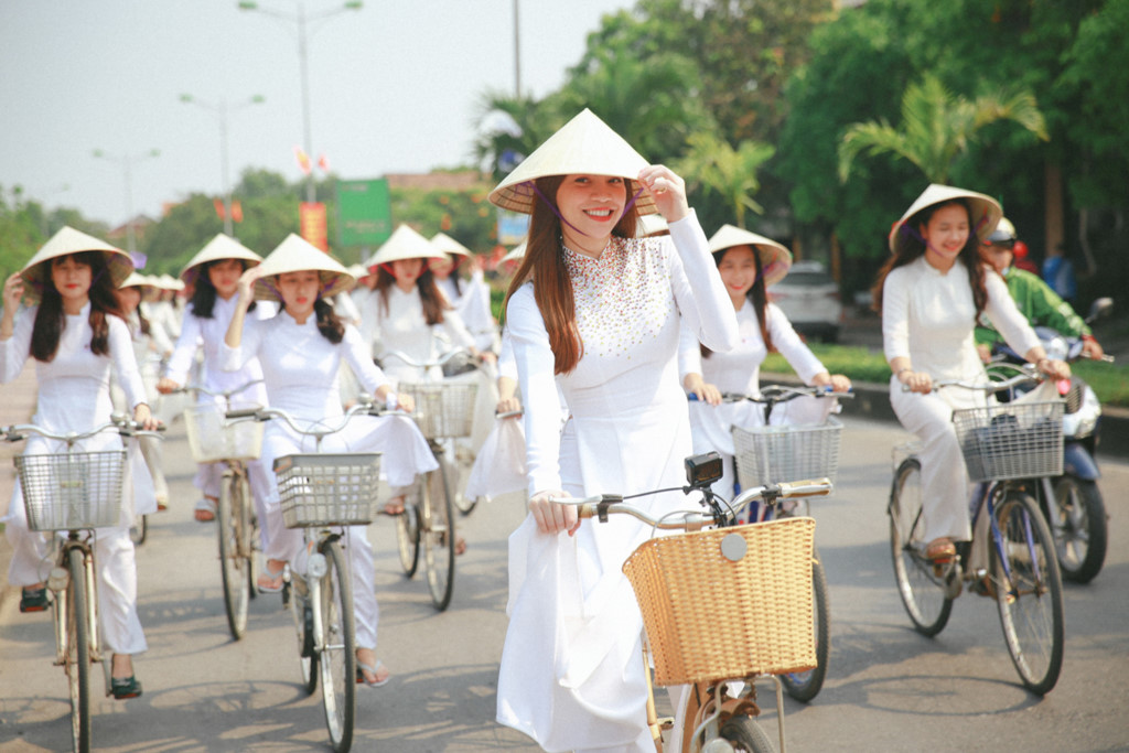 Các bạn nữ đẹp tinh khôi trong tà áo dài trắng đạp xe đạp dành cho học sinh - sinh viên trên đường