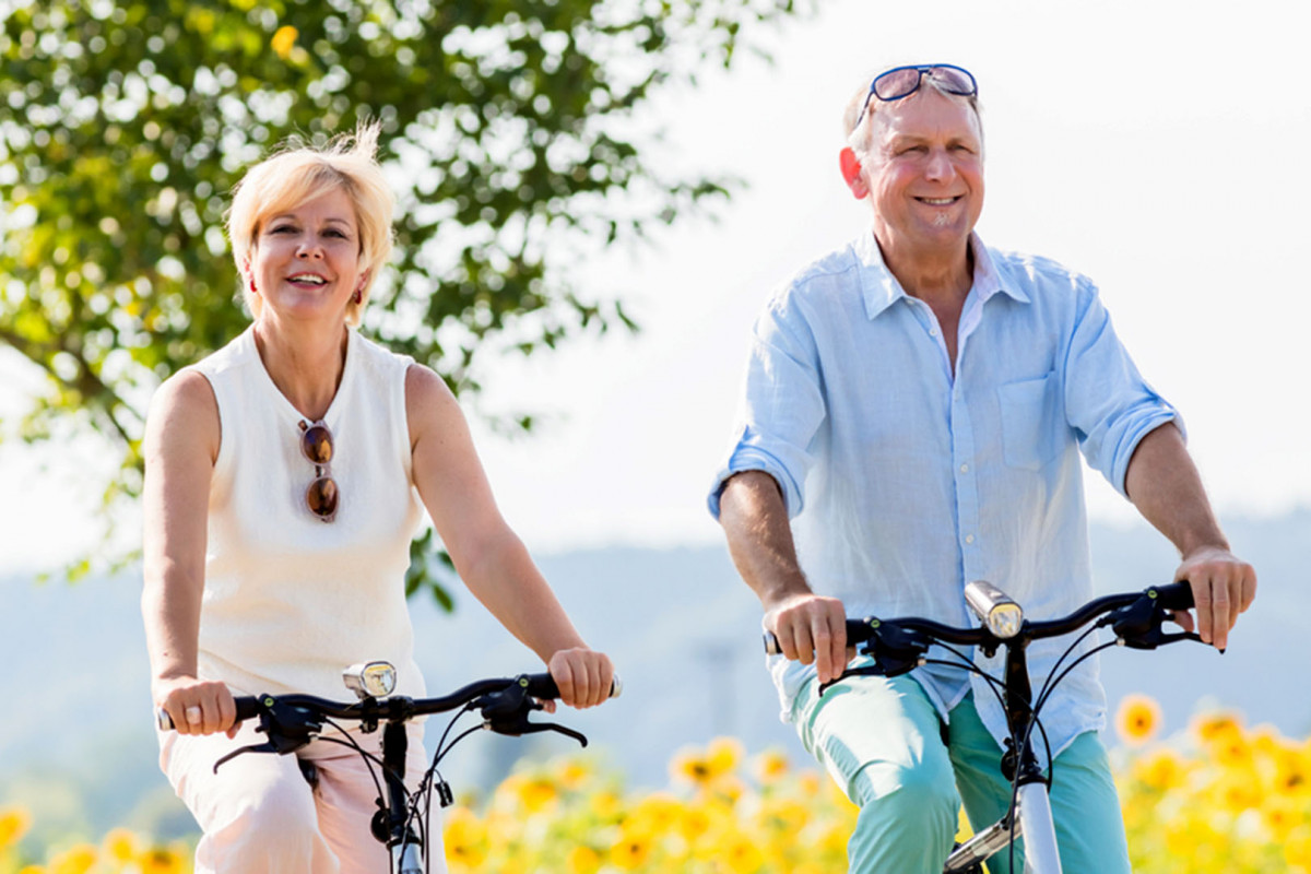 Niềm vui của hai người lớn tuổi khi được đạp xe đạp thể thao dưới nắng sáng