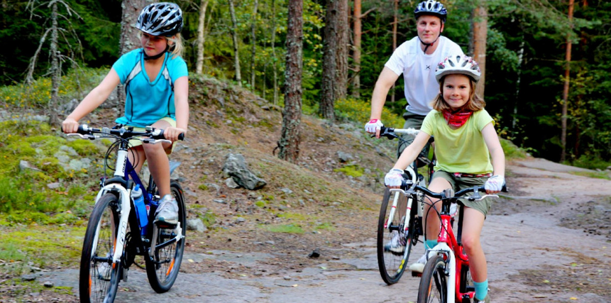 Bố và hai con tập thể dục bằng cách đạp xe trên đường mòn